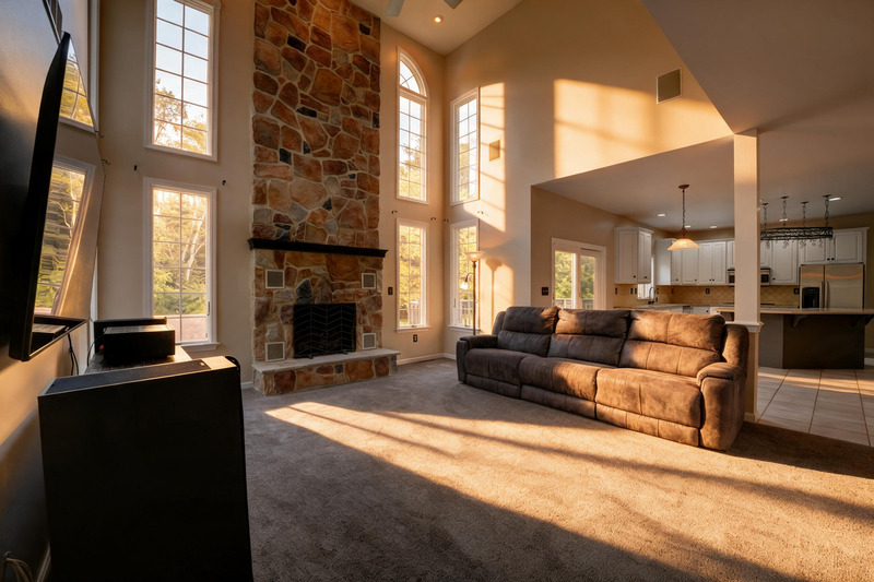 Sunlit double-height living room and stone fireplace in Luxury Residence