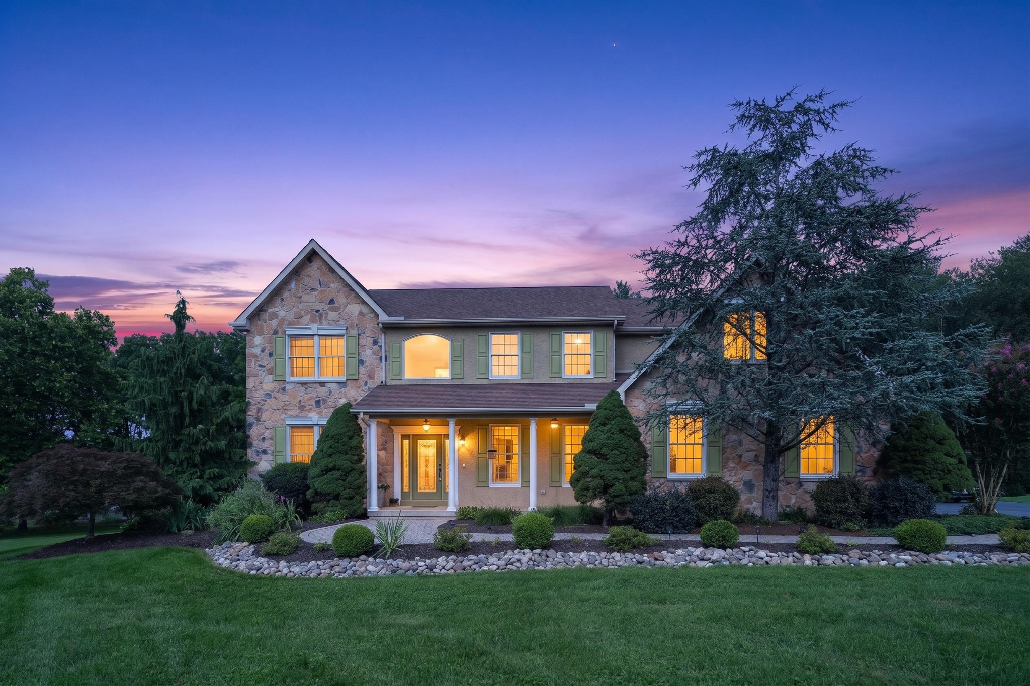 Stone residential home photographed at twilight